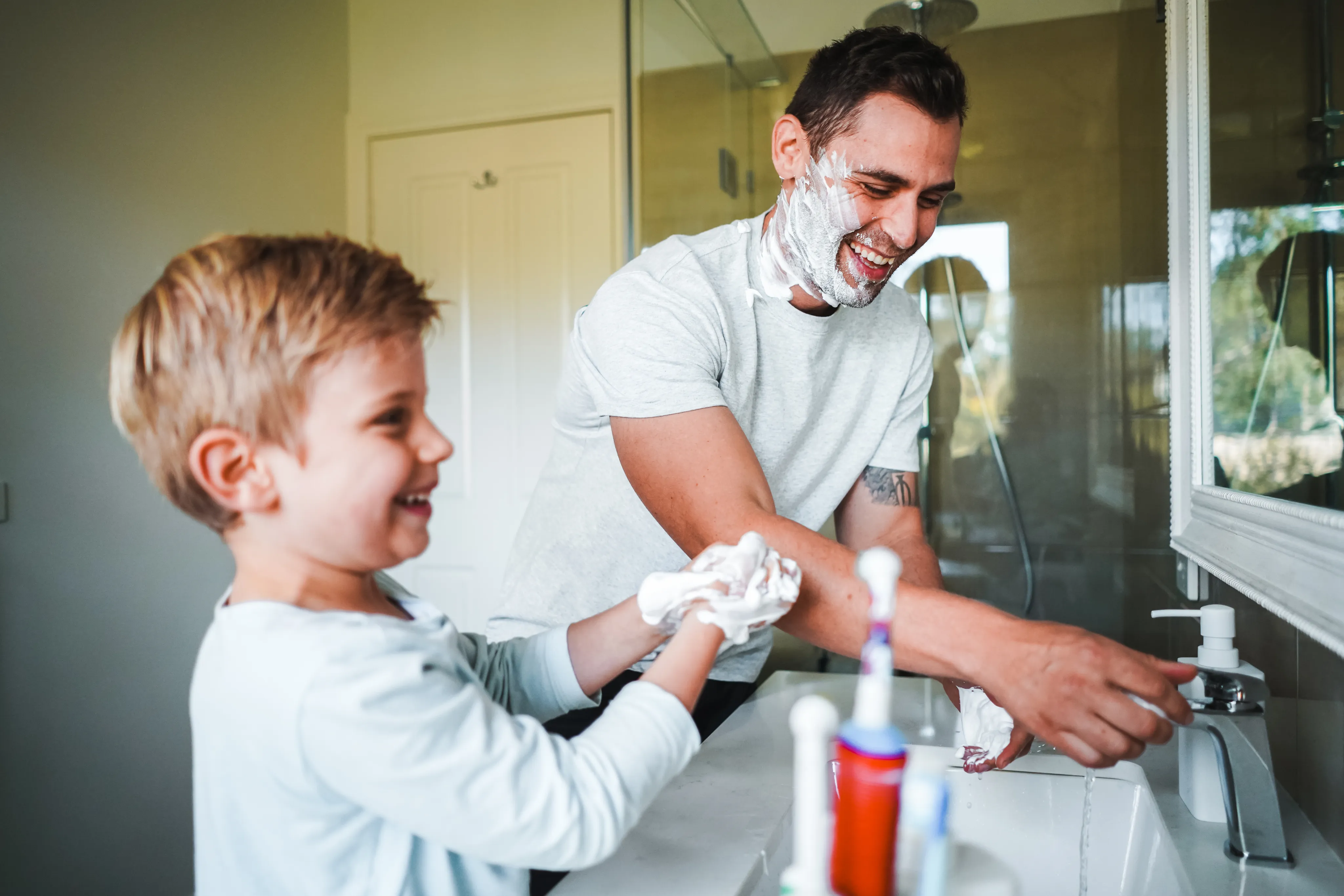 Father and son at the bathroom sink enjoying clean filtered water